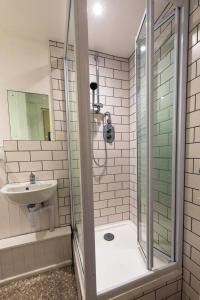 uma casa de banho com um chuveiro e um lavatório. em GuestReady - Riverside Flat em Inverness