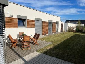 een patio met een tafel en stoelen op een gazon bij Apartmán Business Comfort se zahradou in Hradec Králové