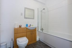a bathroom with a toilet and a sink and a bath tub at GuestReady - Apt perto do centro da cidade in Liverpool