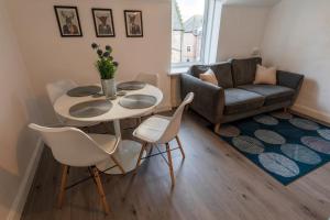 a living room with a table and chairs and a couch at Riverside Flat in Inverness