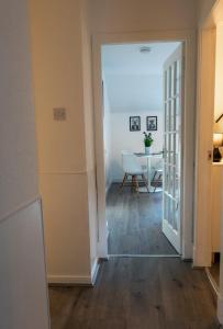 a hallway with a table and a door to a room at Riverside Flat in Inverness