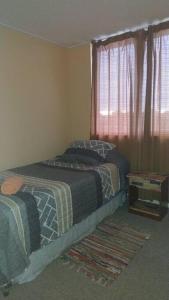Un dormitorio con dos camas y una ventana. en Cómodo Departamento, en Los Ángeles