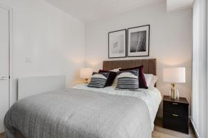 a bedroom with a bed with two lamps on it at GuestReady - Modern stay near World Museum in Liverpool