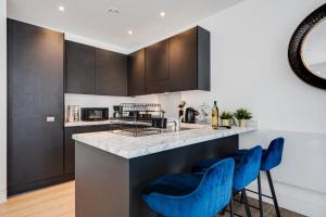 a kitchen with blue stools at a counter at GuestReady - Modern stay near World Museum in Liverpool