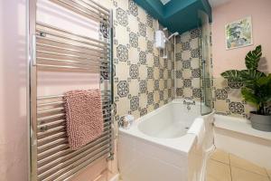 een badkamer met een bad en een wastafel bij GuestReady - Charming haven steps from attractions in Liverpool
