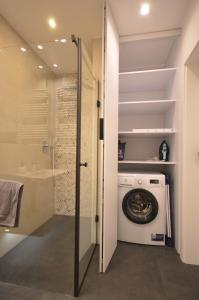 a bathroom with a washing machine and a shower at Wilcza City Center Apartments in Gdańsk
