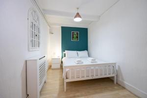 - une chambre avec un lit blanc et un mur bleu dans l'établissement GuestReady - Charming haven steps from attractions, à Liverpool