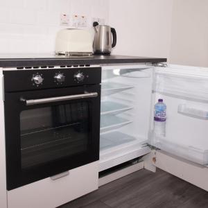 a kitchen with an oven and an open refrigerator at GuestReady - Monochromatic Retreat in Liverpool