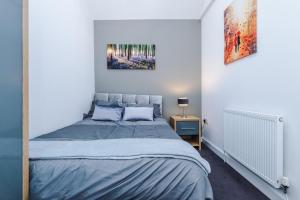 a bedroom with a bed in a white room at GuestReady - Anfield Urban Escape in Liverpool