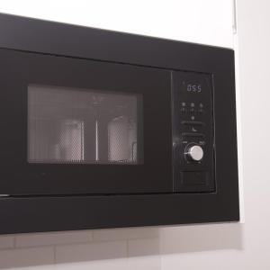 a microwave oven sitting on top of a wall at GuestReady - Monochromatic Retreat in Liverpool
