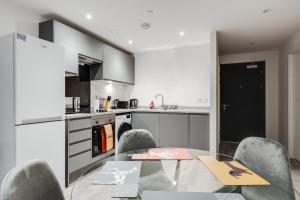 uma cozinha com uma mesa de vidro e cadeiras numa cozinha em GuestReady - An enjoyable stay in Vauxhall em Liverpool