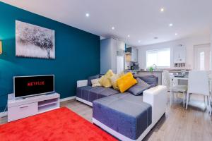 a living room with a couch and a tv at GuestReady - Anfield Urban Escape in Liverpool