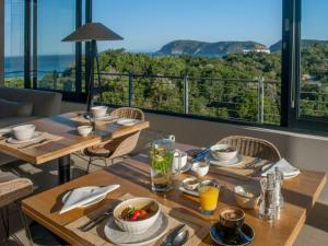 a dining table with a view of the ocean at Christiana Lodge in Plettenberg Bay