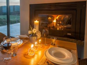 a table with a plate of food and a fireplace at Christiana Lodge in Plettenberg Bay