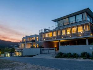 a large house with a sunset in the background at Christiana Lodge in Plettenberg Bay