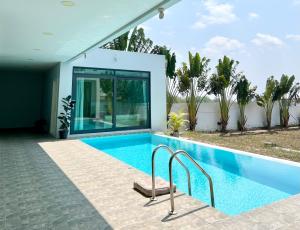 una piscina frente a una casa en 芭提雅湖景泳池别墅2 en Nong Prue