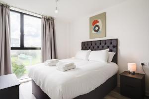 a bedroom with a large white bed with a window at GuestReady - One perfect resting place in Vauxhall in Liverpool