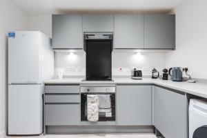 a kitchen with white appliances and white cabinets at GuestReady - Conforto de luxo em Liverpool in Liverpool