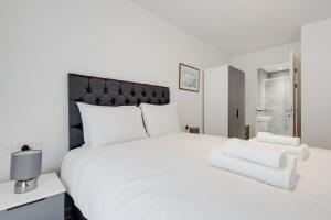 a white bedroom with a large bed with white pillows at GuestReady - Conforto de luxo em Liverpool in Liverpool