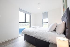 een slaapkamer met een groot bed met witte lakens en kussens bij GuestReady - Liverpool's best near World Museum in Liverpool