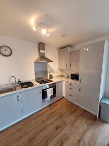 a kitchen with white cabinets and a stove top oven at Skylark Apartment in Peacehaven