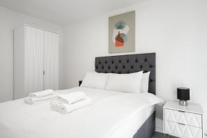 1 dormitorio blanco con 1 cama grande con sábanas blancas en GuestReady - A lovely hideaway in Vauxhall en Liverpool
