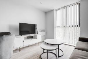 a living room with a tv and a table at GuestReady - A lovely hideaway in Vauxhall in Liverpool