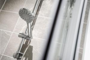 a shower with a shower head in a bathroom at GuestReady - A lovely hideaway in Vauxhall in Liverpool