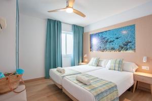 1 dormitorio con 1 cama y una pintura en la pared en Apartaments Edificio Puerto, en Colonia de Sant Jordi
