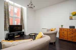 a living room with a couch and a tv at GuestReady - One modern and calm city refuge in Liverpool