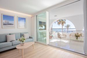 een woonkamer met een bank en uitzicht op de oceaan bij Apartaments Edificio Puerto in Colonia Sant Jordi