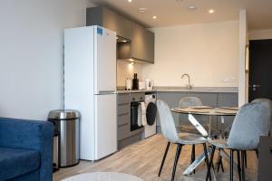 uma cozinha com uma mesa e cadeiras e um frigorífico em GuestReady - Escapadela de luxo em Liverpool em Liverpool