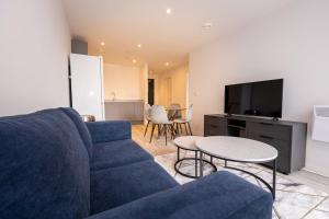 ein Wohnzimmer mit einem blauen Sofa und einem Tisch in der Unterkunft GuestReady - Escapadela de luxo em Liverpool in Liverpool