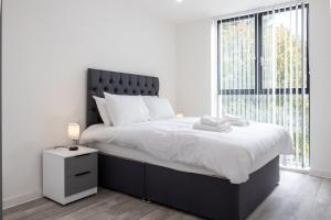 a bedroom with a large bed with a large window at GuestReady - Elegant Tranquility in Vauxhall in Liverpool