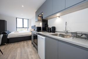 a kitchen with a sink and a bed in a room at GuestReady - Estúdio deslumbrante em Liverpool in Liverpool