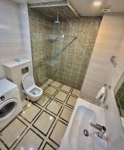 a bathroom with a toilet and a sink and a shower at Aparthotel Holiday Lux Batumi in Batumi