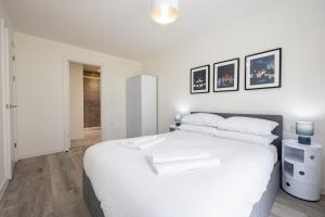 a white bedroom with a large white bed in it at GuestReady - A family retreat in Vauxhall in Liverpool
