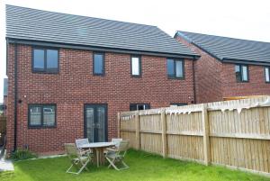 a brick house with a table and chairs in the yard at GuestReady - Humble Abode by Anfield Stadium in Liverpool