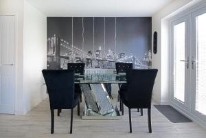 a dining room with a glass table and chairs at GuestReady - Humble Abode by Anfield Stadium in Liverpool