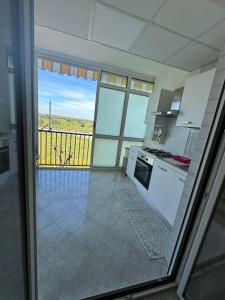 eine Küche mit weißen Geräten und einen Balkon mit Aussicht in der Unterkunft Antonio's Home in Bari