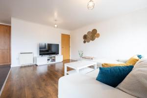 sala de estar con sofá blanco y TV en GuestReady - Modern retreat in Liverpool en Liverpool