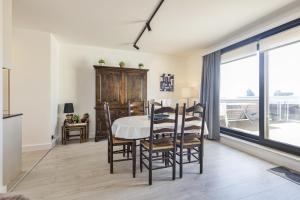a dining room with a table and chairs and a window at Zeebries 0505 e5 in Wenduine