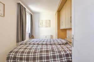 a bedroom with a bed with a plaid blanket at Zeebries 0505 e5 in Wenduine