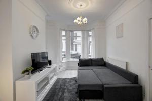 een woonkamer met een bank en een tv bij GuestReady - A monochrome home in Anfield in Liverpool