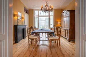 een eetkamer met een tafel en stoelen en een kroonluchter bij NEW Hello Zeeland - Vakantiehuis Markt 10 in Domburg