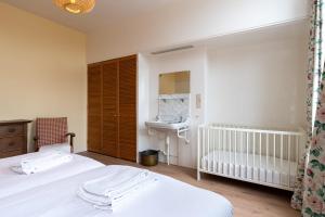 1 dormitorio con 2 camas, lavamanos y cuna en NEW Hello Zeeland - Vakantiehuis Markt 10 en Domburg