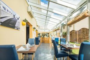 a restaurant with wooden tables and blue chairs at Airways Hotels Frankfurt Airport West in Raunheim