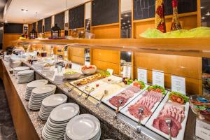 una línea de buffet con carne y otros productos alimenticios en Airways Hotels Frankfurt Airport West en Raunheim