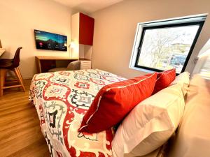 a bedroom with a bed with red pillows and a window at RIACENTRUM - Smart Residence in Aveiro