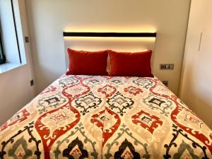 a bedroom with a bed with a quilt on it at RIACENTRUM - Smart Residence in Aveiro